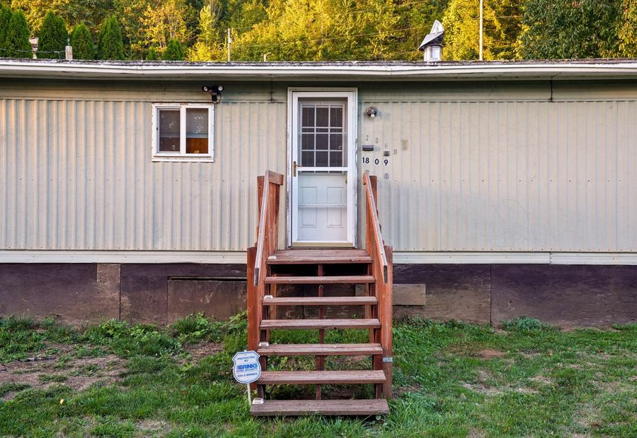 Single-wide manufactured home set on its lot with entry steps and skirting